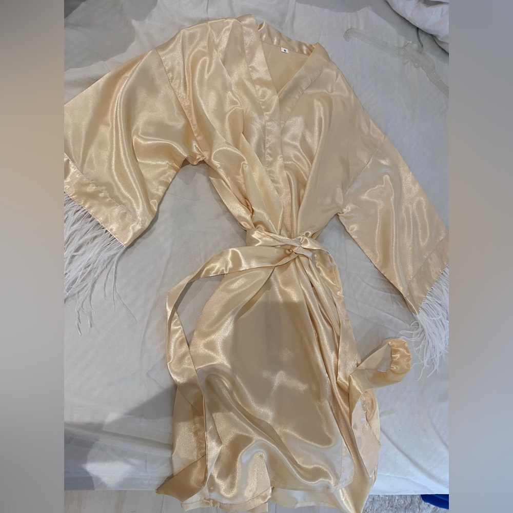 Beige robe with white ostrich feathers on sleeves